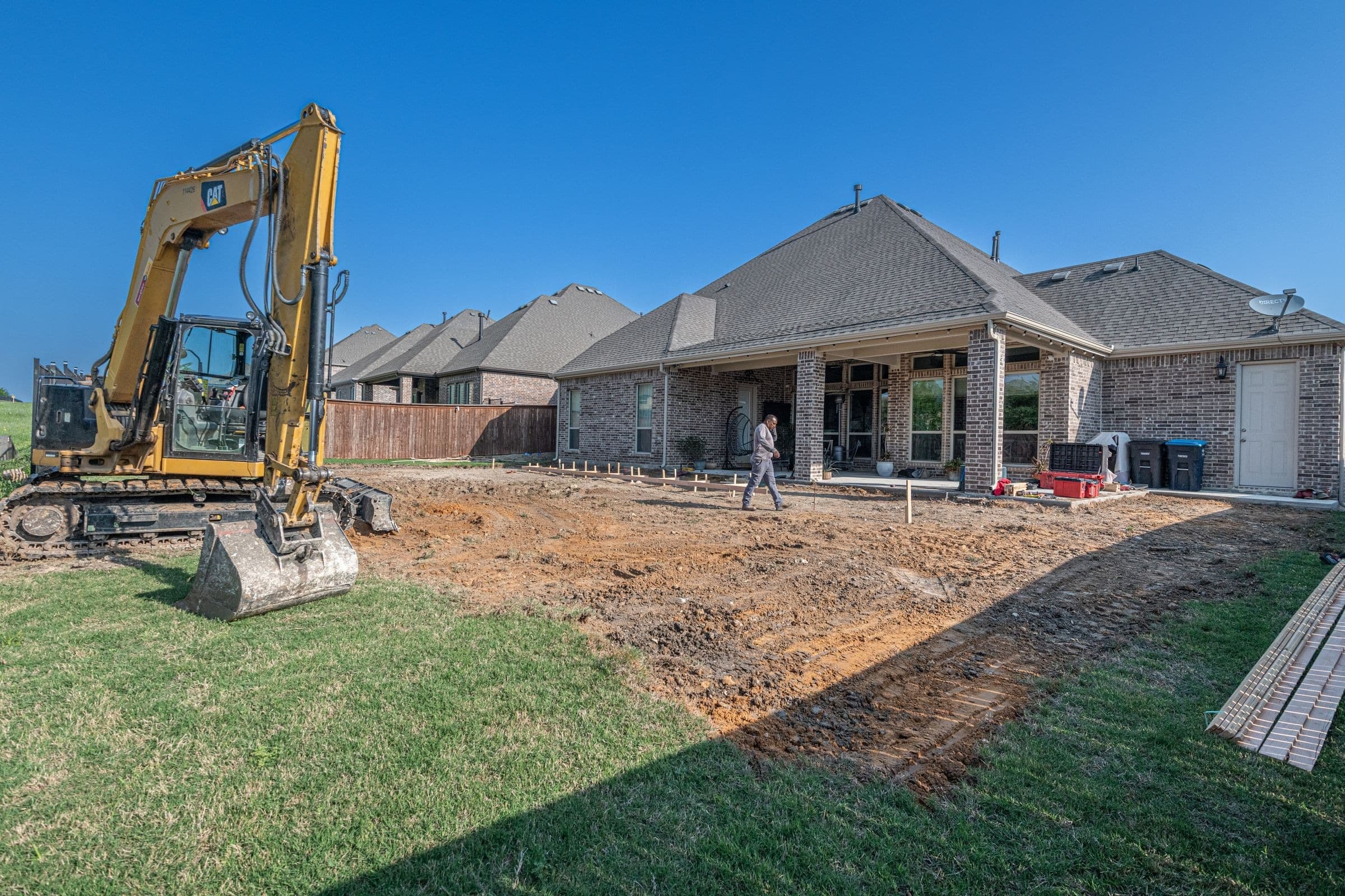 New brick homes and a dirt lot being graded in a Texas subdivision